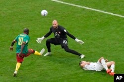 Cameroon's Vincent Aboubakar, left, scores his team's second goal past Serbia's goalkeeper Vanja Milinkovic-Savic during the World Cup match between Cameroon and Serbia at the Al Janoub Stadium in Al Wakrah, Qatar, Nov. 28, 2022.