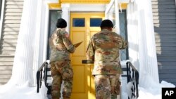 Dos elementos de la Guardia Nacional visitan una casa para ver cómo se encuentran sus ocupantes tras una tormenta invernal, el miércoles 28 de diciembre de 2022, en Buffalo, Nueva York. 