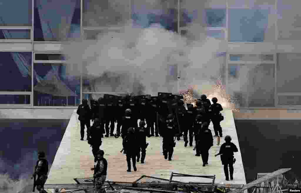 Security forces confront supporters of Brazil&#39;s former President Jair Bolsonaro protest against President Luiz Inacio Lula da Silva, in Planalto Palace, in Brasilia, Jan. 8, 2023.