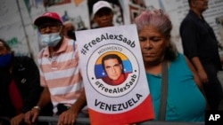 A woman holds a poster showing Colombian-born businessman Alex Saab in a demonstration demanding his release, in Caracas, Venezuela, Dec. 16, 2022. 