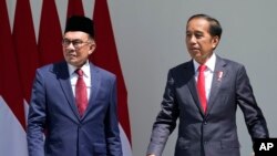 Indonesian President Joko Widodo, right, talks with Malaysian Prime Minister Anwar Ibrahim during their meeting at the presidential palace in Bogor, West Java, Indonesia, Monday, Jan. 9, 2023. (AP Photo/Achmad Ibrahim)