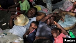 Sejumlah warga yang terpaksa mengungsi dari rumahnya akibat perang antar kelompok bersenjata di Cite Soleil tampak beristirahat di area jalanan Delmas di Port-au-Prince, Haiti, pada 19 November 2022. (Foto: Reuters/Ralph Tedy)