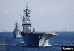 Kapal perusak Pasukan Bela Diri Maritim Jepang (JMSDF) JS Hyuga (DDH-181) memimpin armada JMSDF selama Peninjauan Armada Internasional untuk memperingati 70 tahun berdirinya JMSDF, di Teluk Sagami, lepas pantai Yokosuka, selatan Tokyo, Jepang November 6, 2022. (REUTERS/Issei Kato/Pool)