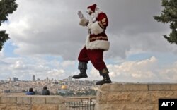 Palestinian Issa Kassissieh, dressed as Santa Claus, prances for a picture on the Mount of Olives in Jerusalem, Dec. 6, 2022.