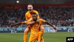 Netherlands' defender Denzel Dumfries celebrates with Netherlands' midfielder Teun Koopmeiners after scoring his team's third goal during the Qatar 2022 World Cup round of 16 on December 3, 2022. 