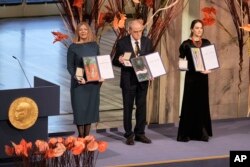 Representatives of the 2022 Nobel Peace Prize laureates, from left: Natalia Pinchuk, the wife of Nobel Peace Prize winner Ales Bialiatski, Yan Rachinsky, chairman of the International Memorial Board and Oleksandra Matviychuk, head of the Ukraine's Center for Civil Liberties pose with awards during the Nobel Peace Prize ceremony at Oslo City Hall, Norway, Dec. 10, 2022.