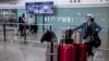 FILE - A woman waits in the arrival hall of the Hong Kong International Airport in Hong Kong on Dec. 8, 2022.