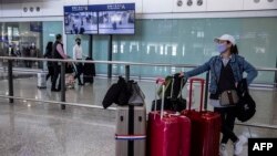 FILE - A woman waits in the arrival hall of the Hong Kong International Airport in Hong Kong on Dec. 8, 2022.