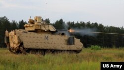FILE - Troopers fire the 25mm canon on a Bradley fighting vehicle at a range in Poland, Aug. 18, 2022.