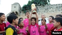 FILE: Tunisian Children holding a replica of the World Cup football trophy. Taken November 13, 2022