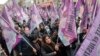 Kurdish activists hold flags during a march to honor three women Kurdish activists who were shot dead in 2013, Dec. 26, 2022 in Paris.