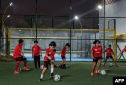 Anak-anak berlatih di lapangan sepak bola di Akademi Olahraga Cedars di ibu kota Qatar, Doha, pada 8 November 2022. (KARIM JAAFAR/AFP)