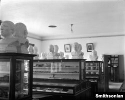 "Exhibit cases of the Department of Physical Anthropology in the National Museum of Natural History, 1911. The exhibit cases contain skulls and bones, on top of the exhibit cases sit busts of Native Americans." MNH-24061