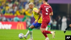 Brazil's Richarlison, left, and Serbia's Milos Veljkovic vie for the ball during the World Cup Group G soccer match between Brazil and Serbia, at Lusail Stadium in Lusail, Qatar, Nov. 24, 2022. 