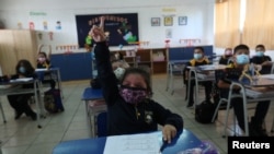 FILE - Students attend a class at a primary school, as schools reopen amid COVID-19 outbreak, in Santiago, Chile, March 1, 2021.