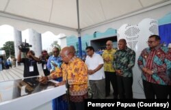 Gubernur Papua Lukas Enembe menandatangani prasasti perempuan kantor gubernur Papua di Jayapura. (Foto: Humas Pemprov Papua)