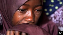 FILE - Husseina Ali, 9, daughter of Aisha Ali, cries inside hut where she found refuge from the floods in Darayami, northeastern Nigeria, Oct. 26, 2022.