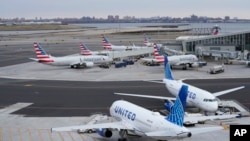 Pesawat dari berbagai maskapai penerbangan AS di landasan Terminal B, Bandara LaGuardia, New York, Rabu, 11 Januari 2023. (AP/Seth Wenig)