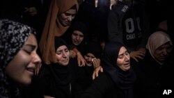 FILE-Palestinian women weep during the funeral of Mohammed al-Shaer, one of eight Palestinians who drowned off the coast of Tunisia, in Rafah, southern Gaza Strip, Dec. 18, 2022.