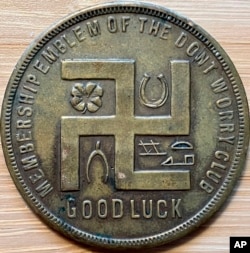 In this photo provided by Holocaust researcher Jeff Kelman in November 2022, the swastika is seen on a coupon-type store token made before the Nazi Party adopted the symbol.