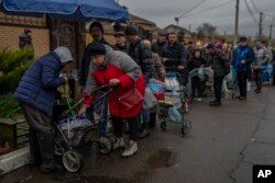 FILE - Residents queue to fill containers with drinking water in Kherson, southern Ukraine, Nov. 20, 2022.