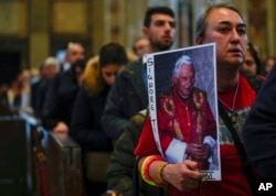 Mourners queue inside St. Peter's Basilica at the Vatican to see Pope Emeritus Benedict XVI lying in state, Jan. 4, 2023.