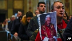 Mourners queue inside St. Peter's Basilica at the Vatican to see Pope Emeritus Benedict XVI lying in state, Jan. 4, 2023.