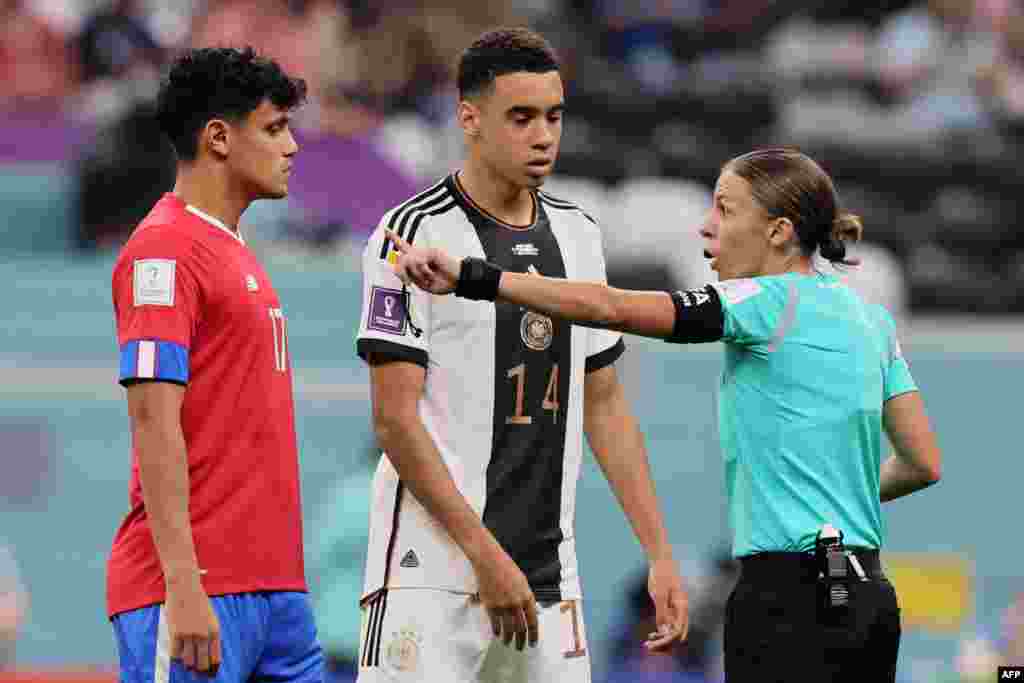 Mobeti piololo ya mwasi ya France Stephanie Frappart (D) azali koloba na milieu ya Costa Rica #17 Yestsin Tejeda (G) na milieu ya Allemagne #14 Jamal Musiala na match ya Mondial Qatar 2022 na stade Al-Bayt, Al Khor, Doha, 1er décembre 2022. (Photo by KAR