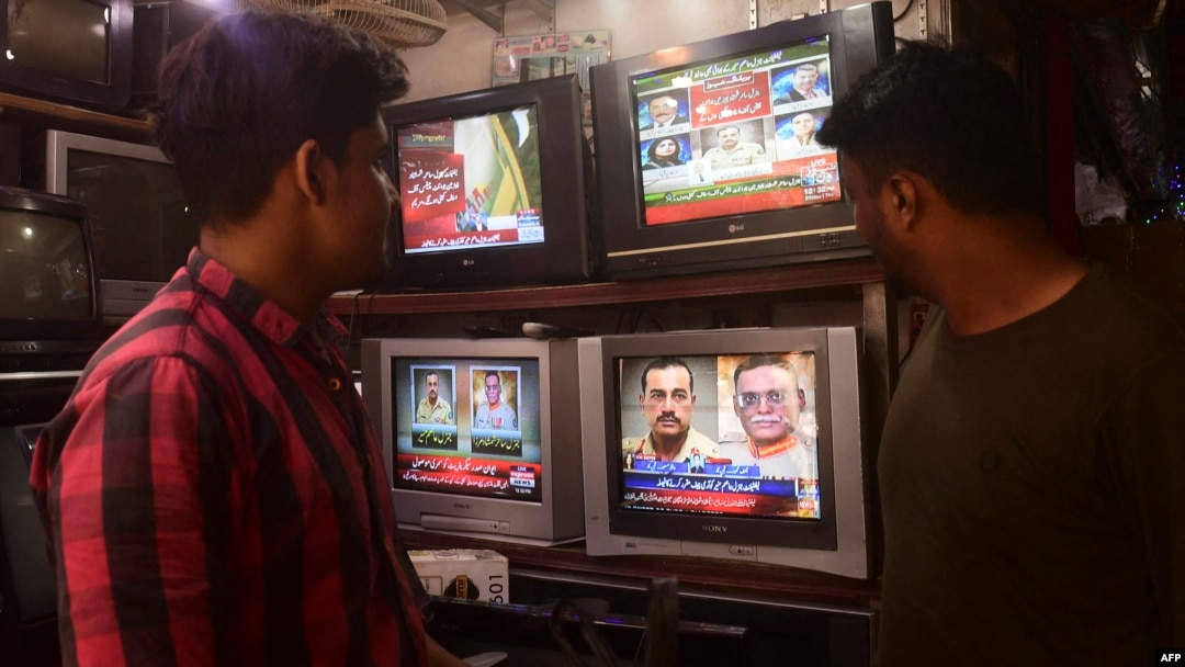 FILE - People watch a TV news broadcast about the nomination of Pakistan's army chief, General Asim Munir, at a market in Karachi, Pakistan, Nov. 24, 2022. Parliament on Nov. 4, 2024, extended the terms of the heads of the armed forces from three years to five years.