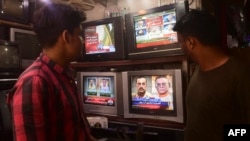 FILE - People watch a TV news broadcast about the nomination of Pakistan's army chief, General Asim Munir, at a market in Karachi, Pakistan, Nov. 24, 2022. Parliament on Nov. 4, 2024, extended the terms of the heads of the armed forces from three years to five years.