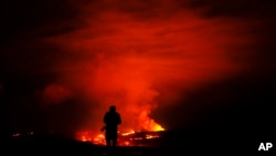 A photographer takes pictures of the Mauna Loa volcano as it erupts Wednesday, Nov. 30, 2022, near Hilo, Hawaii. (AP Photo/Gregory Bull)