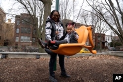 Chicago educator Tamisha Holifield spends time with her 2-year-old daughter Rian Holifield at Nichols Park, Thursday, Dec. 29, 2022, in the Hyde Park neighborhood of Chicago. (AP Photo/Erin Hooley)