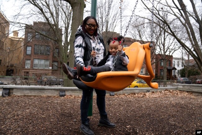 Chicago educator Tamisha Holifield spends time with her 2-year-old daughter Rian Holifield at Nichols Park, Thursday, Dec. 29, 2022, in the Hyde Park neighborhood of Chicago. (AP Photo/Erin Hooley)