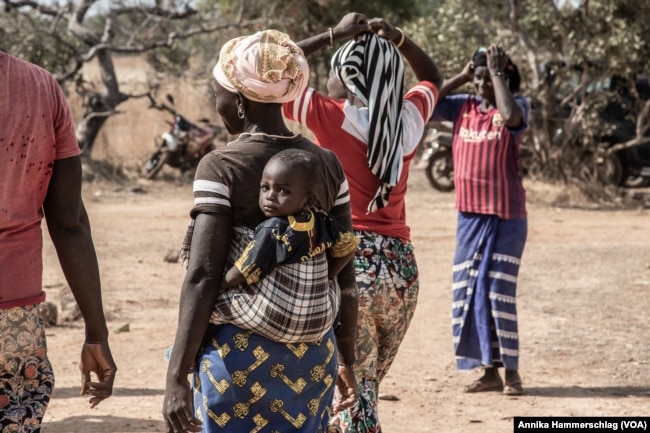 Women make up about half the gold miners in Senegal and often carry their children with them. Here, women work at a gold mine in the country's Kedougou region Nov. 16, 2022.