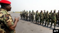 An ECOMOG officer welcomes the contingent of 28 soldiers from Ghana, Benin and Togo, the first elements of a West African peacekeeping force, upon their arrival at the military airport of Abidjan 03 January 2003.