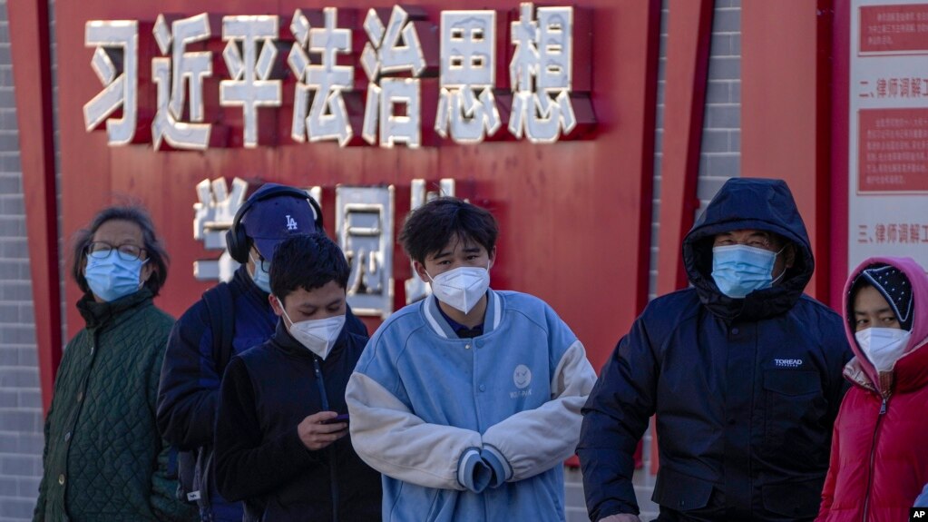 北京市民在宣传习近平思想的标语墙前排队等候进行核算检测。（2022年12月5日）(photo:VOA)