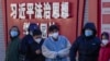 北京市民在宣傳習近平思想的標語牆前排隊等候進行核酸檢測。（2022年12月5日）