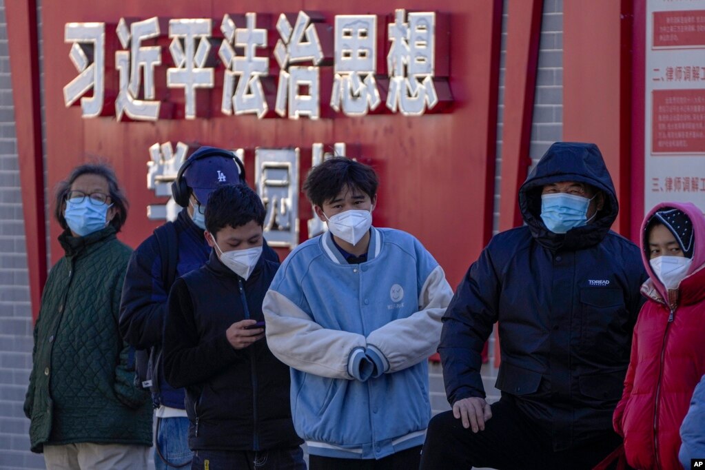 北京市民在宣传习近平思想的标语墙前排队等候进行核算检测。（2022年12月5日）(photo:VOA)