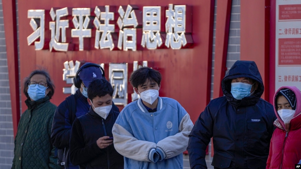 北京市民在宣传习近平思想的标语墙前排队等候进行核酸检测。（2022年12月5日）(photo:VOA)