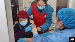 An elderly woman gets vaccinated against COVID-19 at a community health center in Nantong in eastern China's Jiangsu province on Dec. 9, 2022. (Chinatopix Via AP)