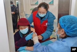 An elderly woman gets vaccinated against COVID-19 at a community health center in Nantong in eastern China's Jiangsu province on Dec. 9, 2022. (Chinatopix Via AP)