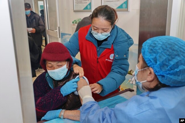 An elderly woman gets vaccinated against COVID-19 at a community health center in Nantong in eastern China's Jiangsu province on Dec. 9, 2022. (Chinatopix Via AP)