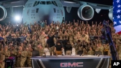 In this handout photo from the US Air Force, American service members participate in a live broadcast with the hosts of Fox NFL Sunday during their Salute to Veterans broadcast, Nov. 13, 2022 at Al-Udeid Air Base in Qatar.