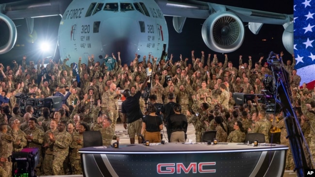 In this handout photo from the US Air Force, American service members participate in a live broadcast with the hosts of Fox NFL Sunday during their Salute to Veterans broadcast, Nov. 13, 2022 at Al-Udeid Air Base in Qatar.