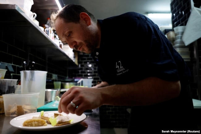 French chef Fabien Borgel prepares a dish of 'Faux-gras', a vegan alternative to foie gras, in his restaurant "42 degres" in Paris, France, December 15, 2022. (REUTERS/Sarah Meyssonnier)