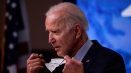 Presiden AS Joe Biden membuka maskernya saat akan berbicara dalam sebuah konferensi pers di Gedung Putih pada 21 April 2021. (Foto: Reuters/Tom Brenner)