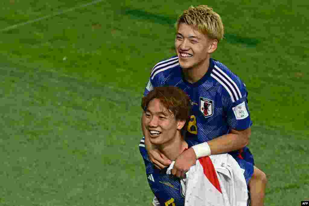 Milieu ya Japon #08 Ritsu Doan (D) adiembeli na mokongo ya défenseur #04 Kou Itakura na nsima na ekolo na bango koleka na 8e ya finale na kolonga Espagne 2-1 na groupe E na stade Khalifa, Doha, 1er décembre 2022. (Photo Jewel SAMAD / AFP)