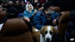 People from Soledar sit inside a bus as they wait to be registered and take up temporary accommodation somewhere near Shakhtarsk, in Russian-controlled Donetsk region, eastern Ukraine, Jan. 13, 2023.