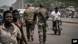 Instruktur militer tentara Prancis berjalan di salah satu jalan utama di Tanguietan, Benin utara, 28 Maret 2022. (Foto: AP)