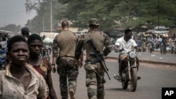 French army military instructors walk on one of the main roads in Tanguietan, northern Benin, March 28, 2022.